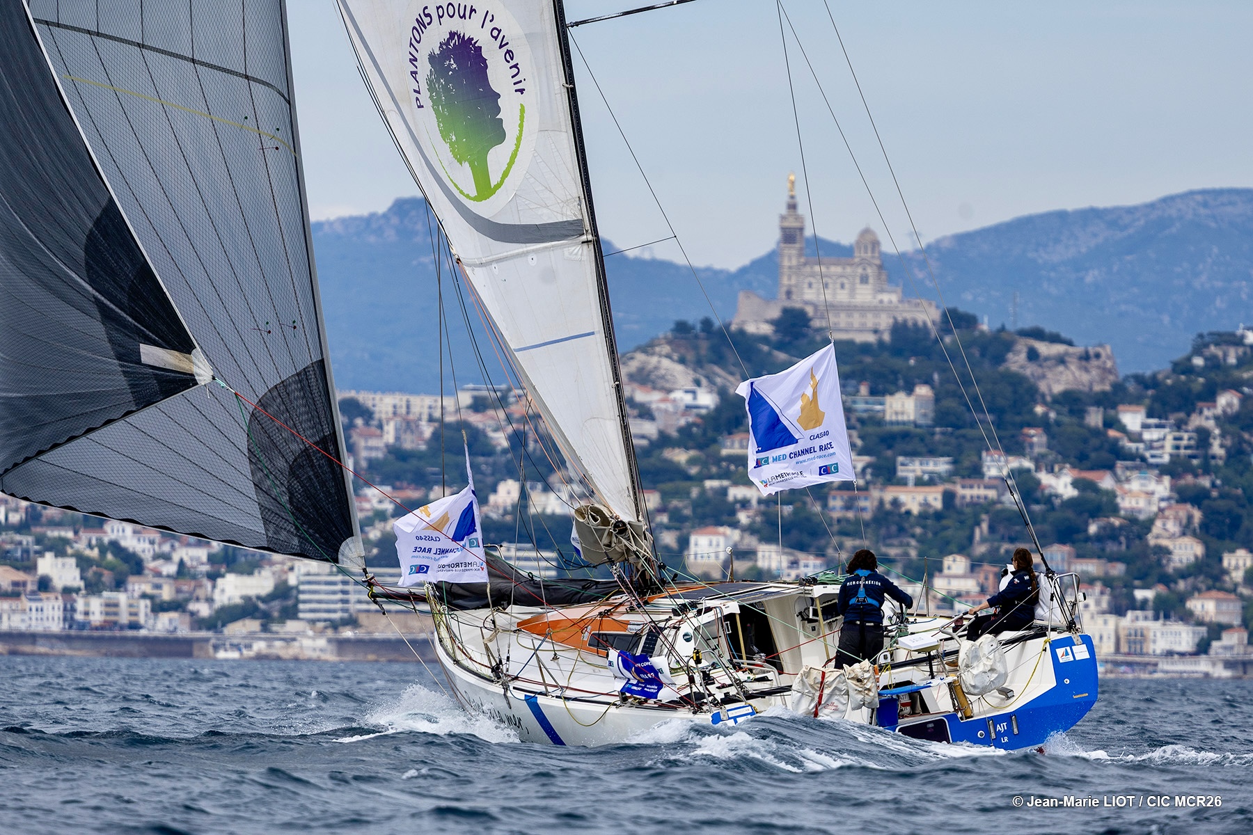 Class40 sailing off Marseille with the city in the background